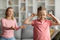 Stubborn Child. Offended little girl covering ears, not to hear mother's scolding