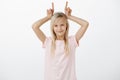 Stubborn cute girl never turn back. Portrait of pleased confident lille kid with blond hair, holding index finger above