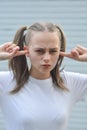 Stubborn, headstrong teen age girl, with fingers in her ear, she does not want to listen. Education problems Royalty Free Stock Photo