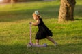 Little girl riding a scooter on grass Royalty Free Stock Photo