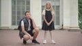 Stubborn schoolgirl standing and talking as elder brother persuading her to go to school. Portrait of Caucasian siblings