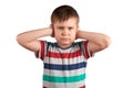 Stubborn young kid, covering his closed ears,ignores what they say, asking for silence, isolated on white background Royalty Free Stock Photo