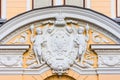 Stucco decoration over the arch - the coat of arms of the two-headed eagle of the Russian Empire with a crown, on the sides are tw