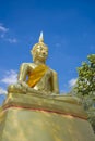 Stucco golden Buddha On a blue sky background
