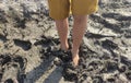 Stuck in the mud. Close-up view of feet walking through muddy path Royalty Free Stock Photo