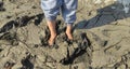 Stuck in the mud. Close-up view of feet walking through muddy path Royalty Free Stock Photo