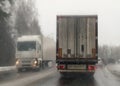 Stuck in traffic in snow storm. Heavy trucks on both sides of the road Royalty Free Stock Photo
