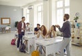 Student answering professor& x27;s question standing near his desk in classroom on university lection.