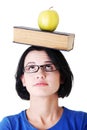 Student with an apple and book on her head Royalty Free Stock Photo