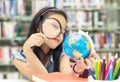 Student asian smiling child studying and education Earth Globe in library, select focus. Royalty Free Stock Photo