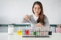 Student asian woman making analyzing and mixing liquid in test tube, color beaker at experiment laboratory in sciense class