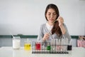 Student asian woman making analyzing and mixing liquid in test tube, color beaker at experiment laboratory in sciense class