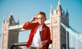 Student with backpack and books. Happy confident pupil ready for education in England. Portrait of boy with Tower bridge