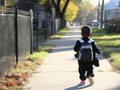A student with a backpack and lunch bag walking to school highlighting the disparities in transportation options between Royalty Free Stock Photo