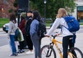 Student on bicycle waiting at campus intersection