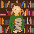 Student boy holds stack of books standing against bookshelf in library