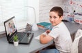 Student boy with laptop having video call with teacher online at home Royalty Free Stock Photo