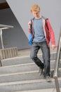 Student boy walking down university stairs