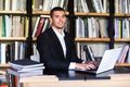 Student boy working on a laptop in the library Royalty Free Stock Photo