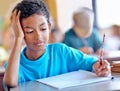 Student, boy and writing notes for studying in classroom, book and problem solving at school. Male person, child and Royalty Free Stock Photo