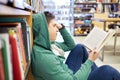 Student boy or young man reading book in library Royalty Free Stock Photo