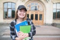 Student in casual clothing with books and notebooks in his hands against the background of a university building Royalty Free Stock Photo