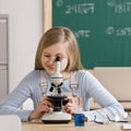 Student in classroom peering into microscope