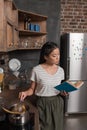 Student cooking and reading book Royalty Free Stock Photo