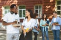 Student couple having break after study, talking and flirting outdoors Royalty Free Stock Photo