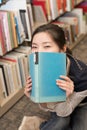 Student covering mouth with book