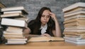 Woman student boring reading book at library with a lot of books in university. Student disheartened reading book for