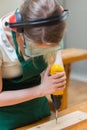 Student drilling a hole in a wooden board at the workbench Royalty Free Stock Photo