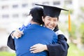 Student and family hug celebrating graduation