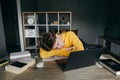 The student fell asleep at home studying on the desktop near books and laptops. Tired young man sleeping on the desk during online Royalty Free Stock Photo