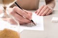Student filling answer sheet at light grey table, closeup. Passing exam Royalty Free Stock Photo