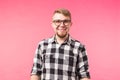 Student, geek and people concept - a young man in glasses smiling over the pink background