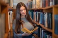 Young student girl reading a book in library Royalty Free Stock Photo