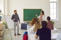 Student girl answering professor& x27;s question standing near desk in classroom on university lection.