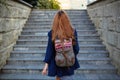 Student girl with a backpack climbing stairs