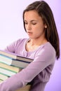 Student girl carry stack of books purple