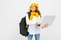 Student girl in casual clothes with a backpack with a laptop in hand on a white background