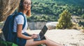 student girl with glasses enjoying vacation in mount using headphones and laptop studying online education in nature, traveler wom Royalty Free Stock Photo