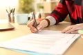 Student girl hands signing contract on a desk Royalty Free Stock Photo