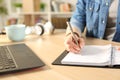 Student girl hands writing on notebook on a desk Royalty Free Stock Photo