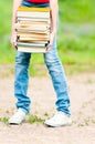 Student girl holding big pile of heavy books Royalty Free Stock Photo