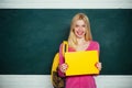 Student girl holding empty faper for product. Learn with fun. Funny female teacher sitting at her workplace and teaching Royalty Free Stock Photo