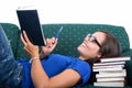 Student girl laid on couch smiling holding notebook