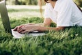 Student girl with laptop outdoors. woman lying on the grass with a computer, surfing the Internet or preparing for exams. Royalty Free Stock Photo