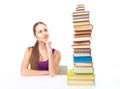 Student girl looking at high stack of books