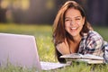 Student girl lying down on the grass. she working on laptop and smiling Royalty Free Stock Photo